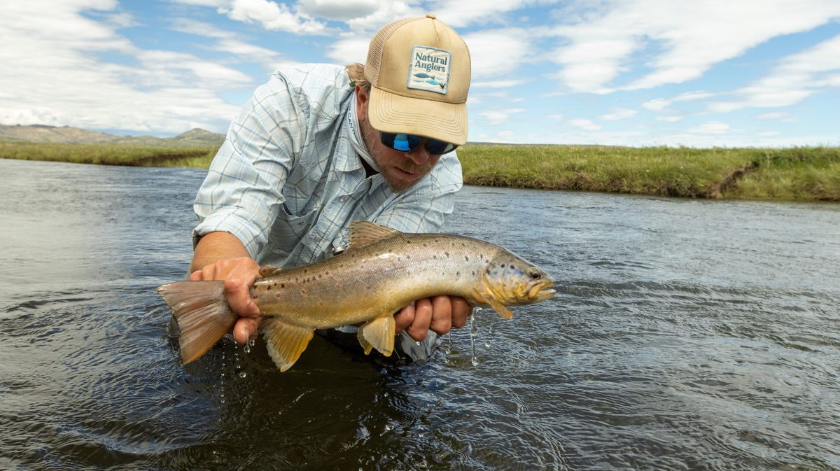 Angler with a trout on the river